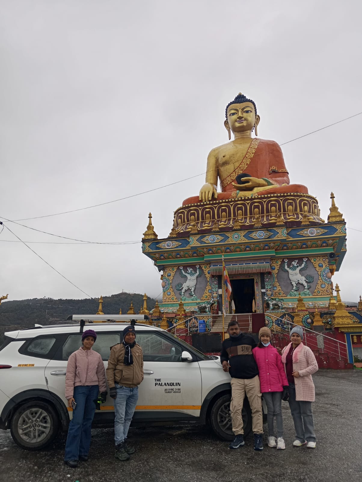 Guests and driver with PalanQuin car at giant Buddha statue Tawang